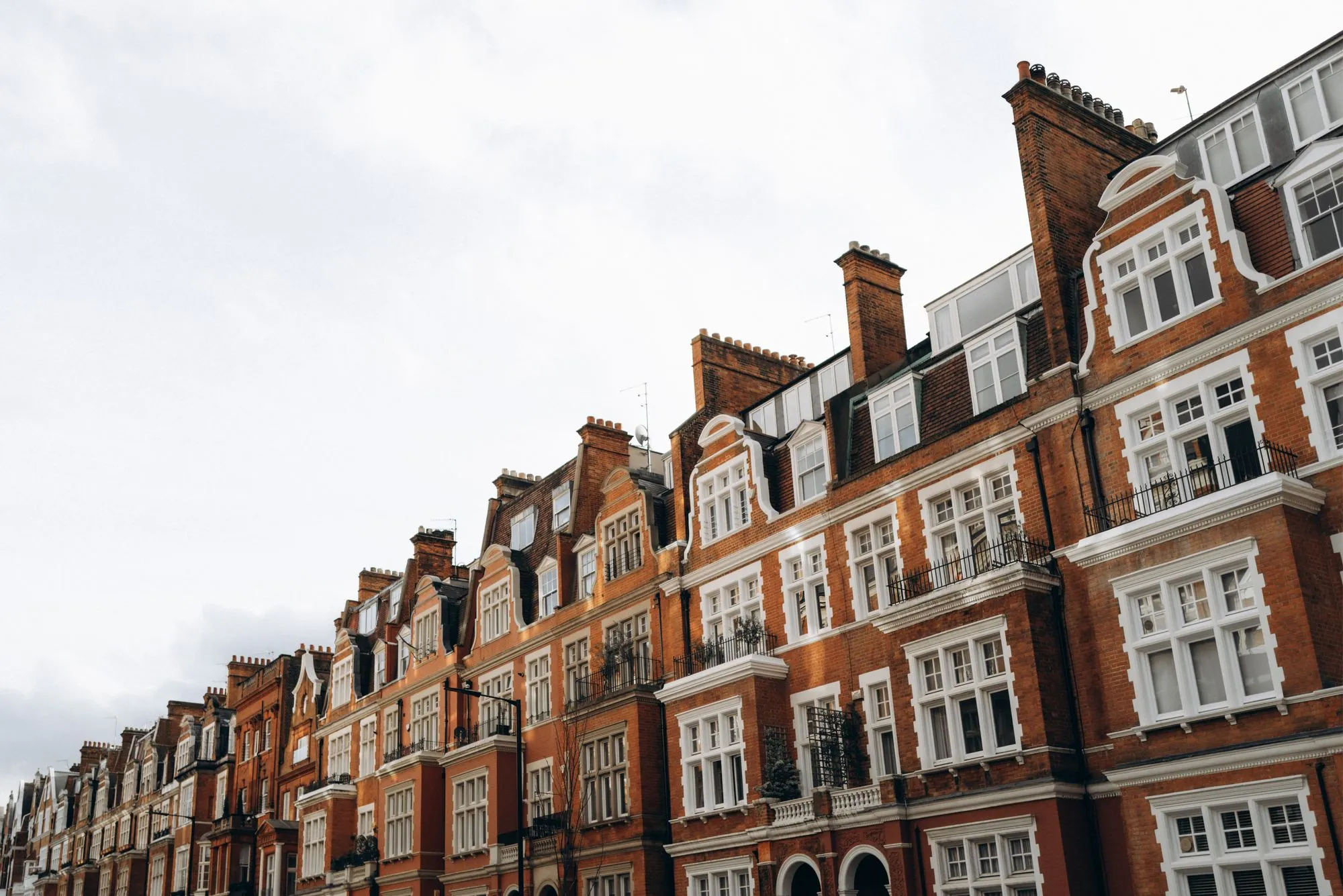 A long row of red-brick Victorian mansion blocks in London